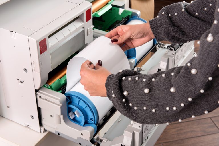 Woman adjusting a roll of new photo paper
